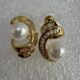 Gold-tone shimmering crystal studded curve with pearl beauty